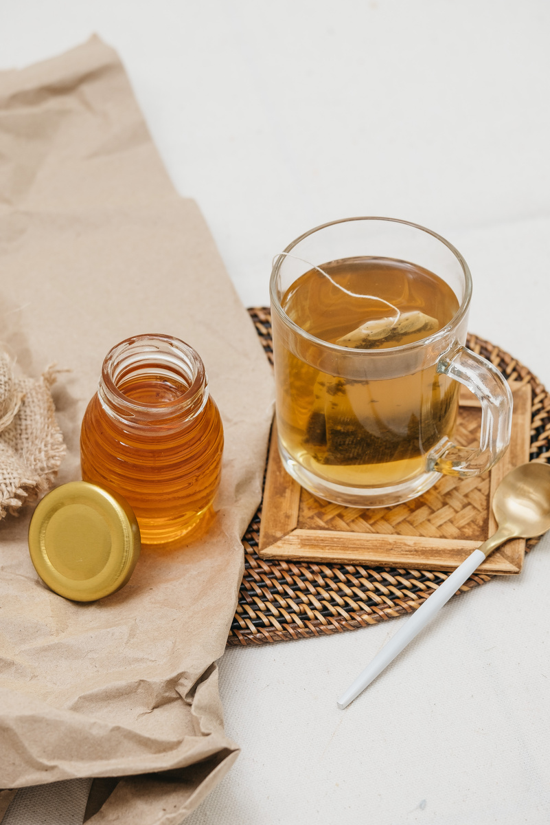 Jar of Honey and Cup of Tea on a Table